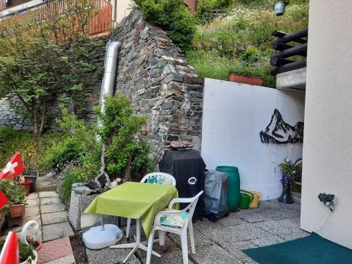 a patio with a table and chairs and a wall at Bodmen 3 Apartments von Privat in Zermatt in Zermatt