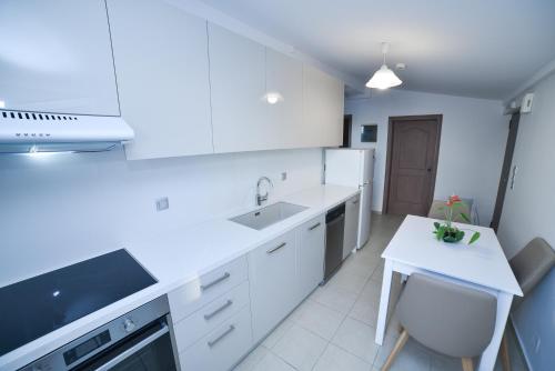 a white kitchen with a sink and a counter at Apartments Stoudios Georgias in Arkoudi