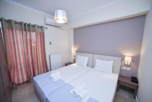 a bedroom with a white bed and a red curtain at Apartments Stoudios Georgias in Arkoudi
