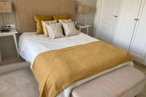 1 dormitorio con 1 cama grande con manta amarilla en Apartamento en Playa Real, en 1ª línea de playa, en Marbella