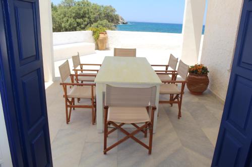 a table and chairs on a balcony with the beach at Beach Villa Akrotiri in Engares
