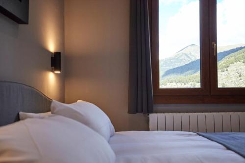 a bedroom with a bed with a window with a view at Soldeu Gall de Bosc Luxury Apartment apt Bon aire in Soldeu