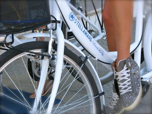 a woman is standing on a bike with her shoes on at Stellamare in Caorle