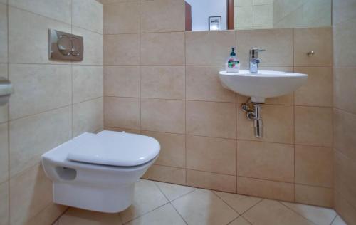 a bathroom with a toilet and a sink at Apartamenty Na Wyspie - Baltic Park - Apartamenty z sypialnią i parkingiem - ul Uzdrowiskowa 24-34 in Świnoujście