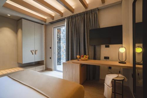 a bedroom with a bed and a desk and a tv at panorama new generation in Sfakia