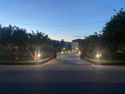 an empty street at night with a house and lights at Borgo Albador Rooms in Posada