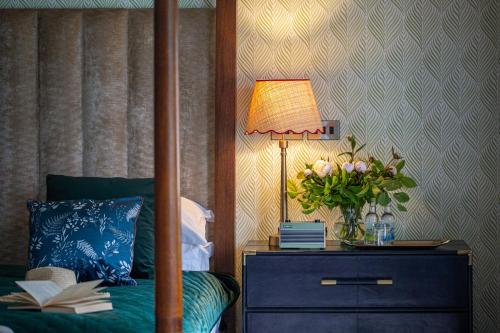 a bedroom with a bed and a table with a lamp at Hogarths in Solihull