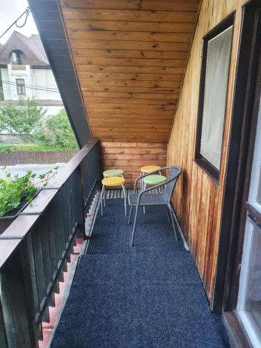 a porch with two chairs and a table at Ubytování v rodinném domě in Hejnice