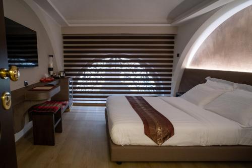 a bedroom with a large bed and a window at ARCADIAN suite&rooms in Turin