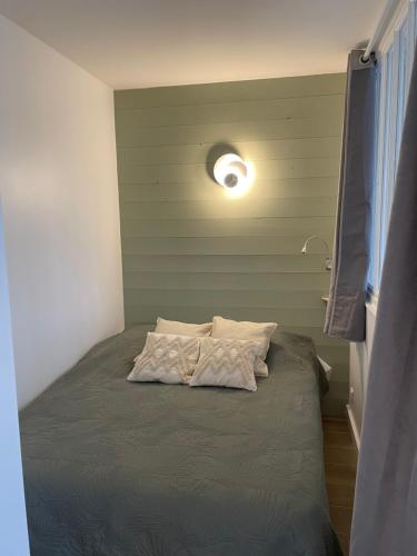Réalaplage studio de charme sur Rivedoux في ريفدو بلاج: سرير في غرفة مع ضوء على الحائط