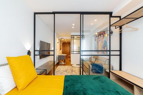 um quarto com uma cama amarela e uma sala de estar em SUITE LUJO CENTRO-NAUTICO-CIES+parking em Vigo