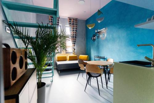 - une cuisine avec des murs bleus, une table et des chaises dans l'établissement Tomosmatik Apartments Koper by Locap Group, à Koper