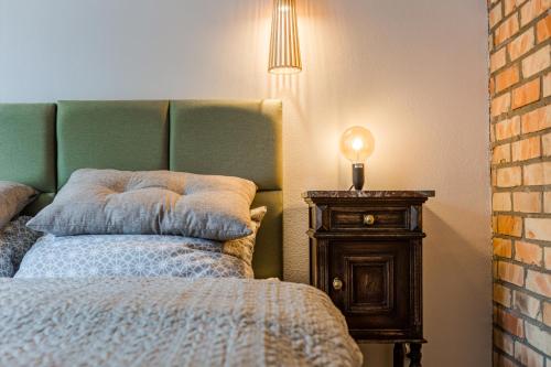 ein Schlafzimmer mit einem Bett und einem Tisch mit einer Lampe in der Unterkunft Pokoje LotNik nad jeziorem in Mrągowo