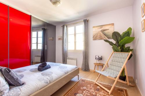 Cette chambre comprend un lit et une chaise. dans l'établissement Providence - ELEGANT F3, VUE INCROYABLE, BALCON,ASCENSEUR, WIFI, à Nice