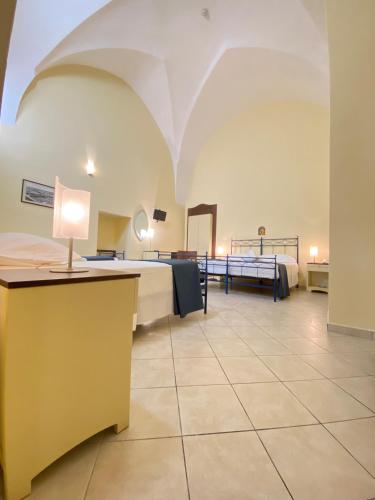 a large room with a bed and a desk at Al Pescatore Hotel & Restaurant in Gallipoli