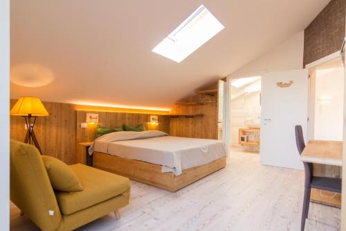 a bedroom with a bed and a couch and a chair at B&B COL DE LE MOLE - DOLOMITI BELLUNESI in Belluno