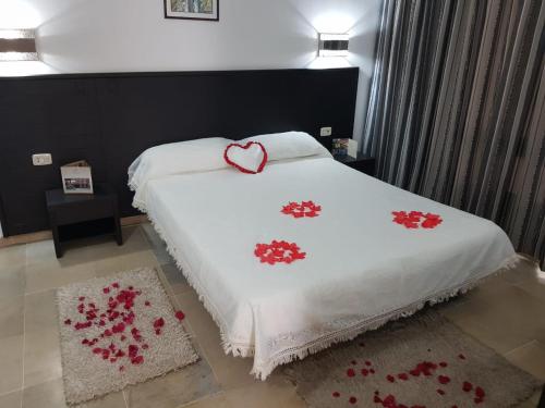 a bed with a white blanket with a heart on it at Andalucia appart hoteL in Bizerte