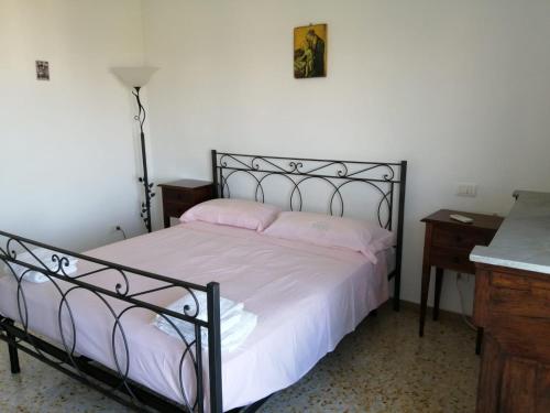 una camera da letto con un letto con lenzuola bianche e cuscini rosa di Sguardo sul Golfo a Massa Lubrense