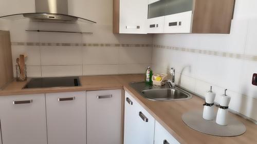 a kitchen with white cabinets and a sink at Renato in Bašanija