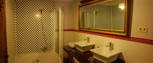 y baño con 2 lavabos, bañera y espejo. en La Noguera de Socasa, en Romancos