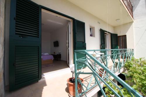 a room with a green door and a balcony at Privatna Soba Gita in Sumartin