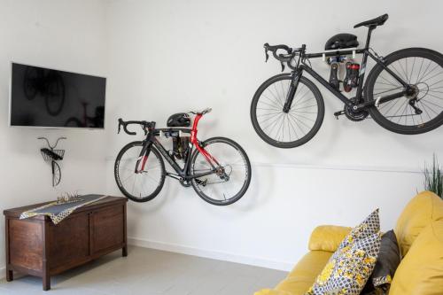 zwei Fahrräder hängen an einer Wand im Wohnzimmer in der Unterkunft Home & Bike Capelli di Venere in Casaletto Spartano