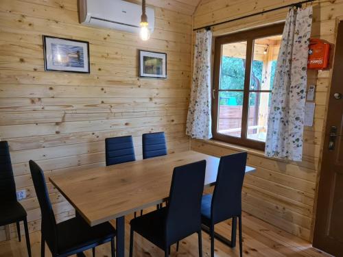 - une salle à manger avec une table et des chaises en bois dans l'établissement Siedlisko nad jeziorem Skarlińskim 5B, mazury, jezioro, domek, bania, à Kurzętnik