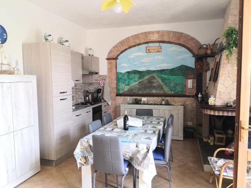 una cocina con una mesa con sillas y una pintura en la pared en Il Bronzetto, en Gonnesa