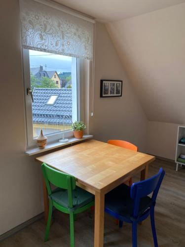 a dining room table with two chairs and a window at Gästehaus VillaVerde in Kelberg