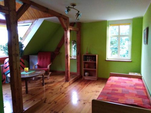 salon z zielonymi ścianami i stołem w obiekcie Alte Schule am See w mieście Biskupiec