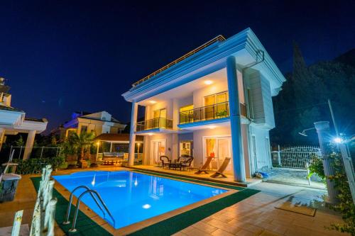 a villa with a swimming pool at night at Milez Sultan luxury villa by Solo Villa in Oludeniz