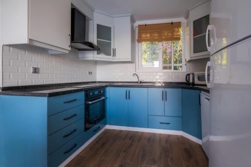 a kitchen with blue cabinets and a sink at Milez Sultan luxury villa by Solo Villa in Oludeniz