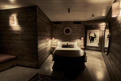 a bedroom with a bed in a room with wooden walls at Carus Cappadocia in Goreme
