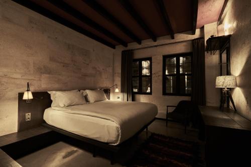 a bedroom with a bed in a room with windows at Carus Cappadocia in Goreme