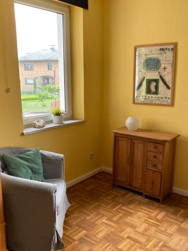 a living room with a chair and a window at Gästehaus VillaVerde in Kelberg
