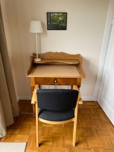 a desk with a chair and a lamp on it at Gästehaus VillaVerde in Kelberg