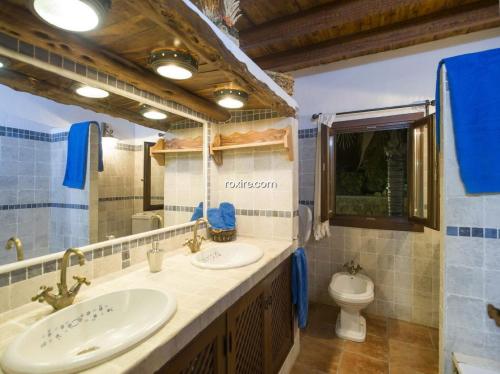 uma casa de banho com 2 lavatórios e um WC em Gran Casa Con Pisina Privada Gimnasio Y Ping Pong em Sant Mateu d’Albarca
