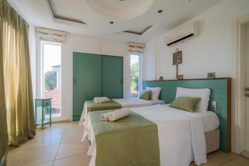 two beds in a room with green and white at Milez Sultan luxury villa by Solo Villa in Oludeniz