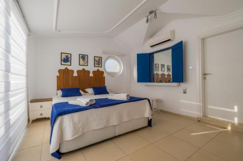a bedroom with a bed with blue and white sheets at Milez Sultan luxury villa by Solo Villa in Oludeniz