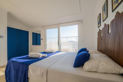 a bedroom with a large bed with blue and white pillows at Milez Sultan luxury villa by Solo Villa in Oludeniz