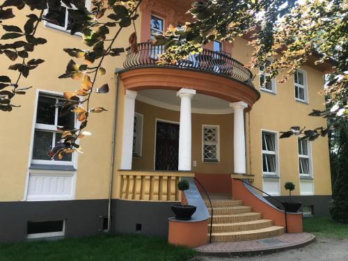 a building with a round balcony on the front of it at Villa Schomberg in Spremberg