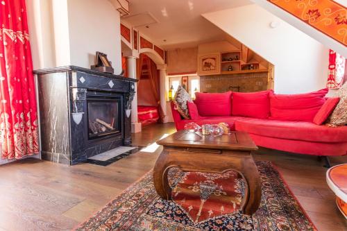 a living room with a red couch and a fireplace at Little India Vijlen appartement 2 in Vijlen