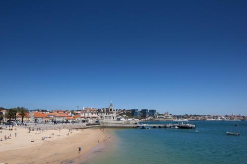a beach filled with lots of boats on a sunny day at Villa Cascais Boutique Hotel in Cascais