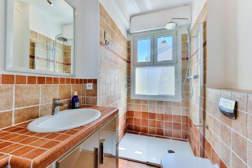 une salle de bain avec un lavabo, une douche et un miroir dans l'établissement La terrasse de Rossini, à Nice