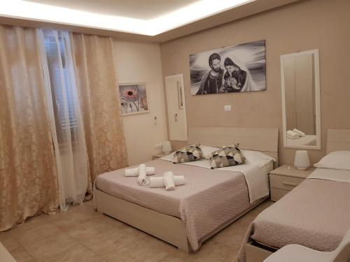 a bedroom with two beds and a mirror at Affittacamere Casa Brajan in Follonica