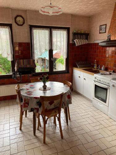 une cuisine avec une table et des chaises dans l'établissement L hotellerie de la gare, à Bruley