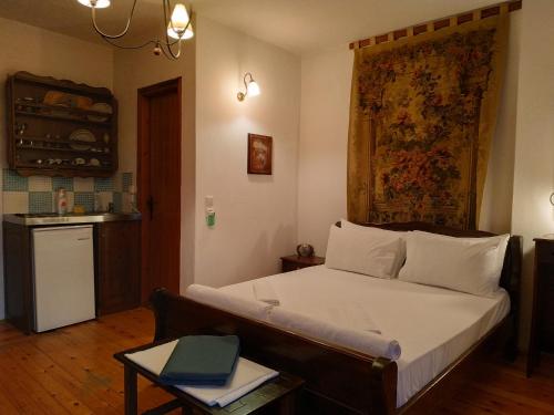1 dormitorio con cama, mesa y cocina en Nefeli, en Palaios Panteleimon