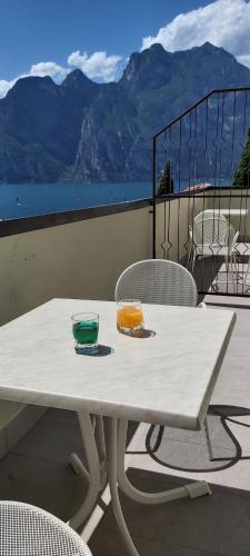 a white table with two glasses on it on a balcony at Casa Romani Lake Apartments in Nago-Torbole