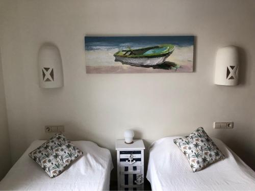 sypialnia z 2 łóżkami i obrazem na ścianie w obiekcie Villa Lena w mieście Playa Blanca