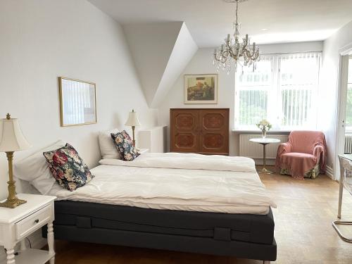 a bedroom with a large bed and a chandelier at aday - Aalborg Mansion - 3 bedroom apartment in Aalborg